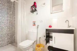 a bathroom with a toilet and a sink at Pousada Casa da Fernanda, Suíte Sky in Praia Grande