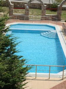 une grande piscine d'eau bleue dans l'établissement Kourtis, à Paramythiá