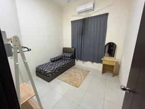 a small bedroom with a bed and a window at Hakim Harmoni Homestay Air Hitam in Air Hitam