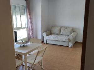 uma sala de estar com um sofá e uma mesa em Beautiful apartment in El Verger with sea views em El Verger