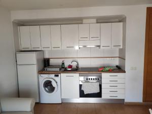 uma cozinha com armários brancos e uma máquina de lavar roupa em Beautiful apartment in El Verger with sea views em El Verger