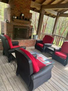 a screened in porch with chairs and a fireplace at Oxford Chalet Getaway with Lake/Beach Access in Oxford