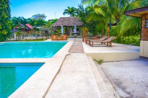 - une piscine avec des bancs et un kiosque dans l'établissement Native House Resort by Cocotel, à Moalboal