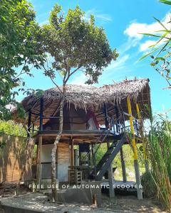 een boomhut met een rieten dak bij Cabanas de Nacpan Camping Resort in El Nido