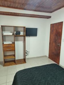 a room with a bed and a cabinet and a television at Departamento Duvivier II in Resistencia