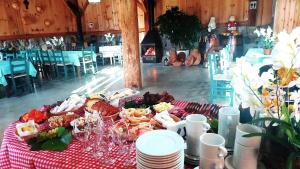 a table with food on a red and white table cloth at Casarão Biazolli in Farroupilha
