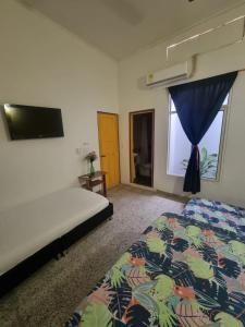 1 dormitorio con 1 cama, TV y ventana en Casa de Luna, en La Dorada