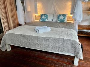 een slaapkamer met een bed met twee handdoeken erop bij Omala Village Gili Air in Gili Air