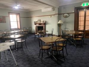 a room with tables and chairs and a fireplace at The Light Horse Hotel in Harden
