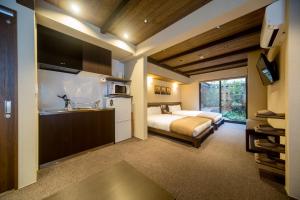a bedroom with a bed and a kitchen with a sink at RESI STAY Nishiki in Kyoto