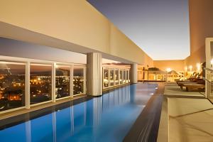 una piscina en un edificio con vistas a la ciudad en True América apart-hotel, en Campos dos Goytacazes