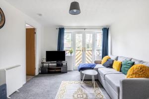 a living room with a couch and a tv at Two bedroom flat near Colchester Hospital with free parking and internet in Mile End