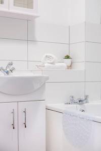a white bathroom with two sinks and white cabinets at Two bedroom flat near Colchester Hospital with free parking and internet in Mile End +8 photos