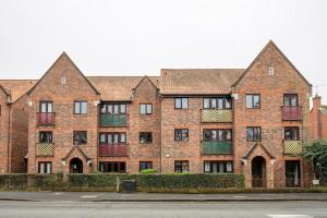 a large brick building with several windows on a street at Two bedroom flat near Colchester Hospital with free parking and internet in Mile End