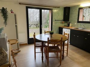 cocina con mesa, sillas y fregadero en Appartement 4 personnes - CHALET COSY Mont Dore, en Le Mont-Dore