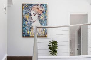 a painting of a woman hanging on a wall at Sandcastles at the Beach - Linen Supplied & Beds Ready on Arrival in Fingal Bay
