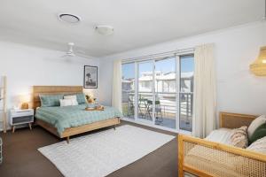a bedroom with a bed and a large window at Sandcastles at the Beach - Linen Supplied & Beds Ready on Arrival in Fingal Bay