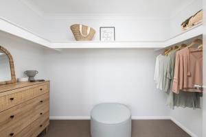 a dressing room with a mirror and a stool at Sandcastles at the Beach - Linen Supplied & Beds Ready on Arrival in Fingal Bay