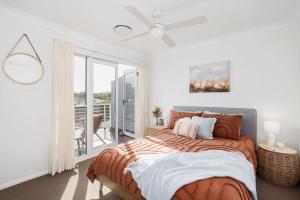 a bedroom with a bed and a balcony at Sandcastles at the Beach - Linen Supplied & Beds Ready on Arrival in Fingal Bay