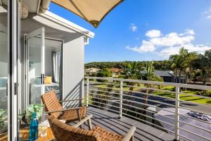 a balcony with two chairs and a view of the ocean at Sandcastles at the Beach - Linen Supplied & Beds Ready on Arrival in Fingal Bay