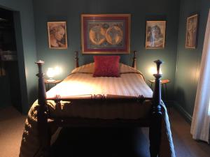 a bedroom with a bed with a red pillow on it at Lady Hamilton in Stratford
