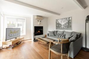 a living room with a couch and a fireplace at The Outlook over Lac -Tremblant by Instant Suites in Mont-Tremblant