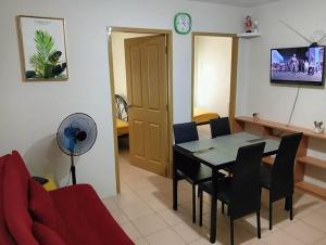 un soggiorno con un tavolo e un divano rosso di 2- bedroom condo in Davao a Davao