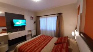 Habitación de hotel con cama y TV de pantalla plana. en NIZA II - Planta Baja. Dto.C en Villa Carlos Paz
