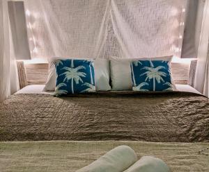 Una cama con almohadas azules y blancas. en Omala Village Gili Air, en Gili Air