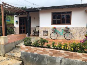 una bicicleta estacionada fuera de una casa con flores en Cabaña VioletaZap, en Zapatoca