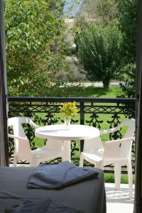 a table with a vase of flowers on a balcony at Stella Studios in Laganas