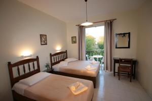 a hotel room with two beds and a window at Stella Studios in Laganas