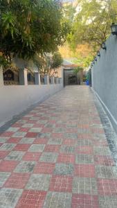 a brick walkway with trees and a building at Elegant & Luxurious Villa at Film Nagar, Jubilee Hills near Apollo in Hyderabad