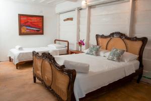 1 dormitorio con 2 camas y sillas de mimbre en Entre Bosques Tayrona en Los Naranjos