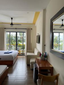 a hotel room with a bed and a couch and a table at Coral Riverside Homestay & Hostel in Hoi An