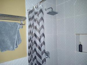 a shower with a black and white shower curtain at 9 Residences Seminyak in Seminyak
