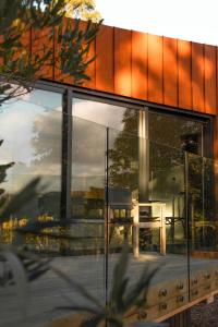 una casa con finestre in vetro e un tavolo su una terrazza di Tussock Hill Vineyard Retreats a Christchurch