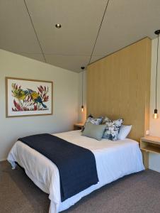 um quarto com uma cama grande num quarto em Tussock Hill Vineyard Retreats em Christchurch