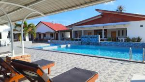 uma villa com uma piscina e uma casa em The Nutshell Chalet Langkawi em Pantai Cenang