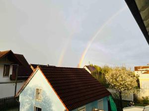 a rainbow is in the sky over a house at Apartment amidst nature-Riverdale, north of Munich in Fahrenzhausen