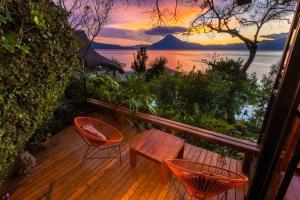 una terrazza con tavolo, sedie e tramonto di Balam Ya a Panajachel