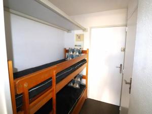 Pokój z 2 łóżkami piętrowymi i drzwiami w obiekcie Studio Cabine 6 Pers. avec Terrasse, Loggia et Parking Privé à 2 Pas de la Plage - FR-1-307-234 w mieście Le Grau-du-Roi