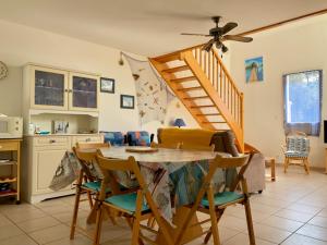kuchnia ze stołem i krzesłami oraz schodami w obiekcie Pavillon à Longeville-sur-Mer, proche plage, 6 pers, 3 ch, terrasse, parking privé - FR-1-336-135 w mieście Longeville-sur-Mer