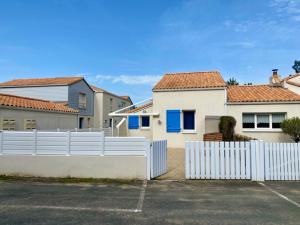 biały płot przed niektórymi domami w obiekcie Pavillon à Longeville-sur-Mer, proche plage, 6 pers, 3 ch, terrasse, parking privé - FR-1-336-135 w mieście Longeville-sur-Mer