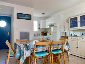 kuchnia i jadalnia ze stołem i krzesłami w obiekcie Pavillon à Longeville-sur-Mer, proche plage, 6 pers, 3 ch, terrasse, parking privé - FR-1-336-135 w mieście Longeville-sur-Mer