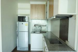 a kitchen with a white refrigerator and white cabinets at The IRIS no.301 : 2 Bedrooms near Huamark Station in Ban Bang Toei (1)