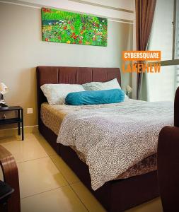 1 dormitorio con 1 cama con una pintura en la pared en Cybersquare Lakeview with Netflix and Disney Hotstar en Cyberjaya