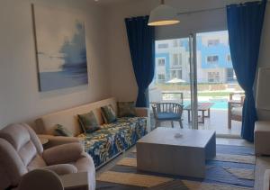 Modern Style Serviced Apartment at Fouka Bay North Coast with Pool and Sea View في مرسى مطروح: غرفة معيشة مع أريكة وطاولة