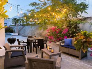 eine Terrasse mit Stühlen, Tischen und Lampen in der Unterkunft Beach villa with cozy terrace in Río Hato