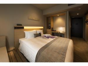 ein Schlafzimmer mit einem großen weißen Bett in einem Zimmer in der Unterkunft HOTEL OLE INN in Shizuoka